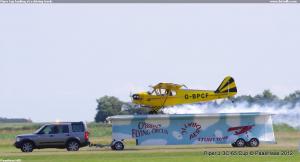 Piper Cup landing at a driving truck.